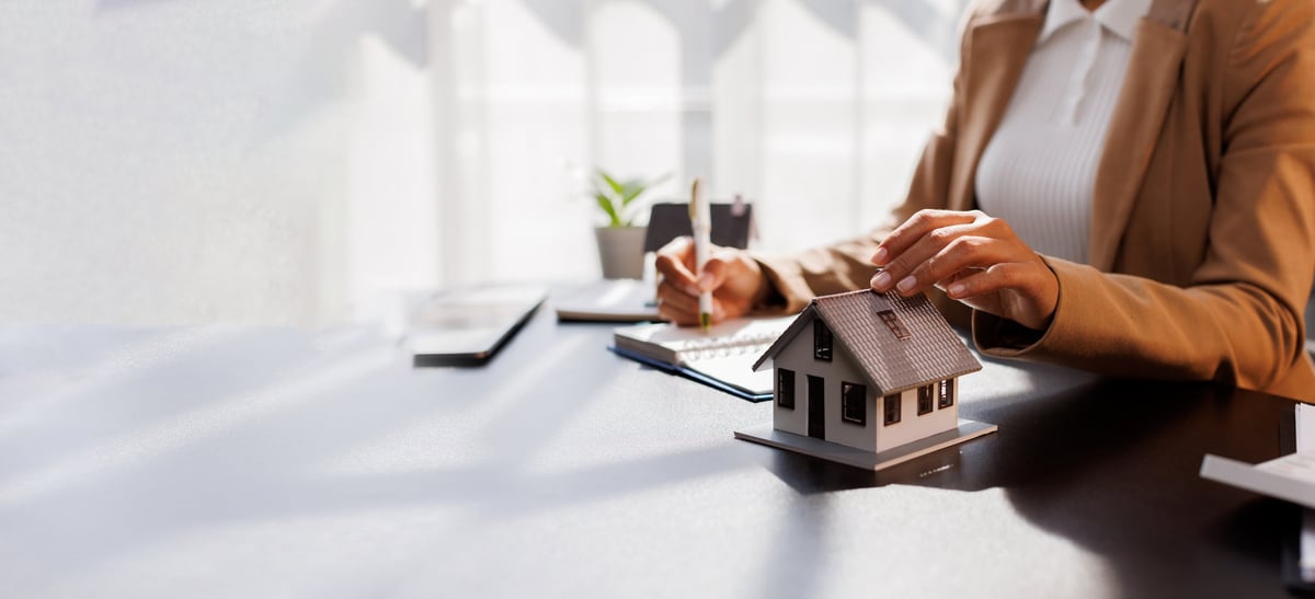 Signing a real-estate purchase agreement at a desk